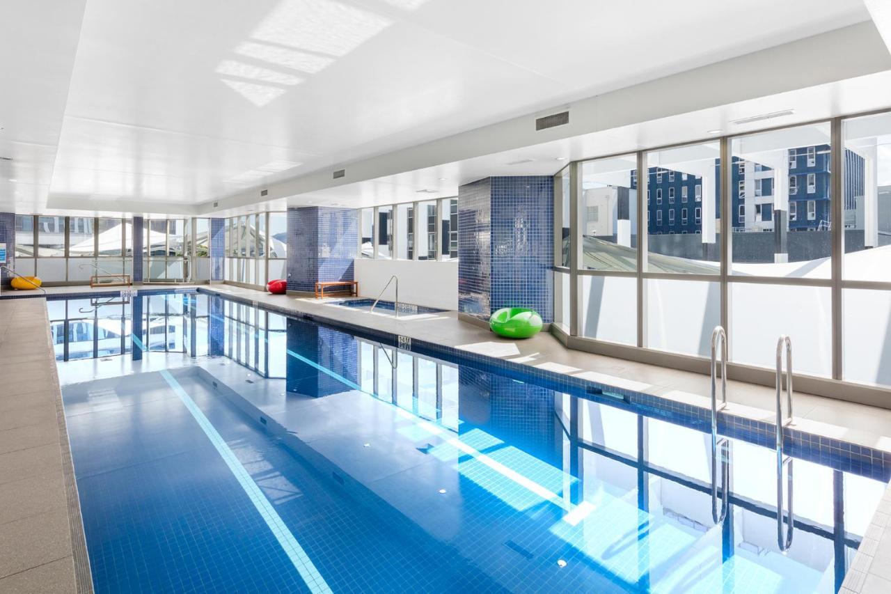 Meriton Suites Herschel Street, Brisbane Exterior foto The photo depicts an indoor swimming pool area. The pool itself features clear blue water and is well-lit by large windows that allow natural light to flood the space. Surrounding the pool are light-colored walls and flooring, which contribute to a c
